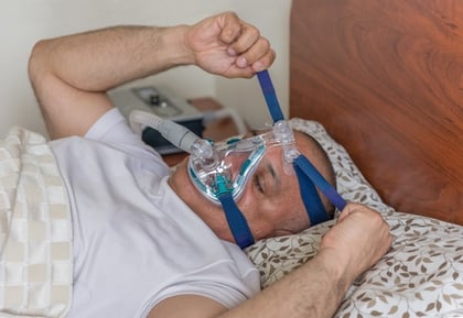 man_adjusting_cpap_maskjpg